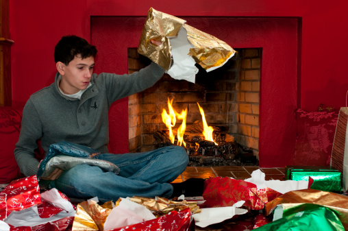 124716731-young-man-unwrapping-presents-gettyimages