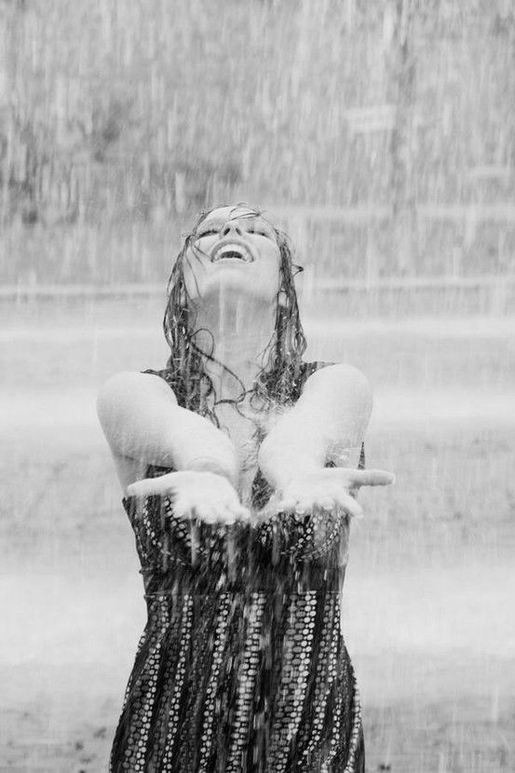 black and white image of woman standing in the rain