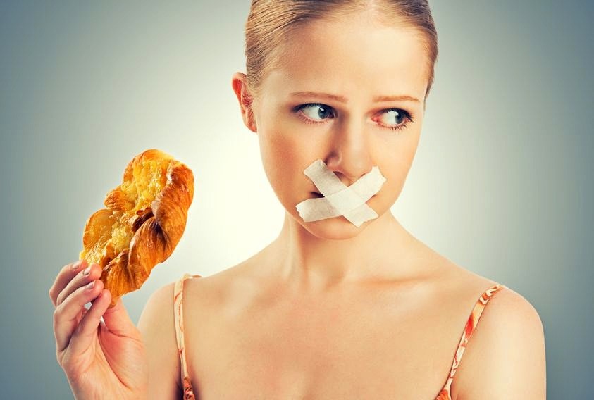 woman holding  fried food with duct tape over her lips