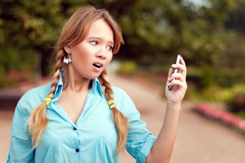 woman staring in shock at phone