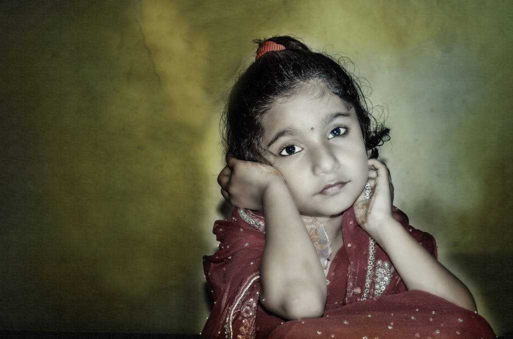 child bride waiting in red saree with dark grungy background