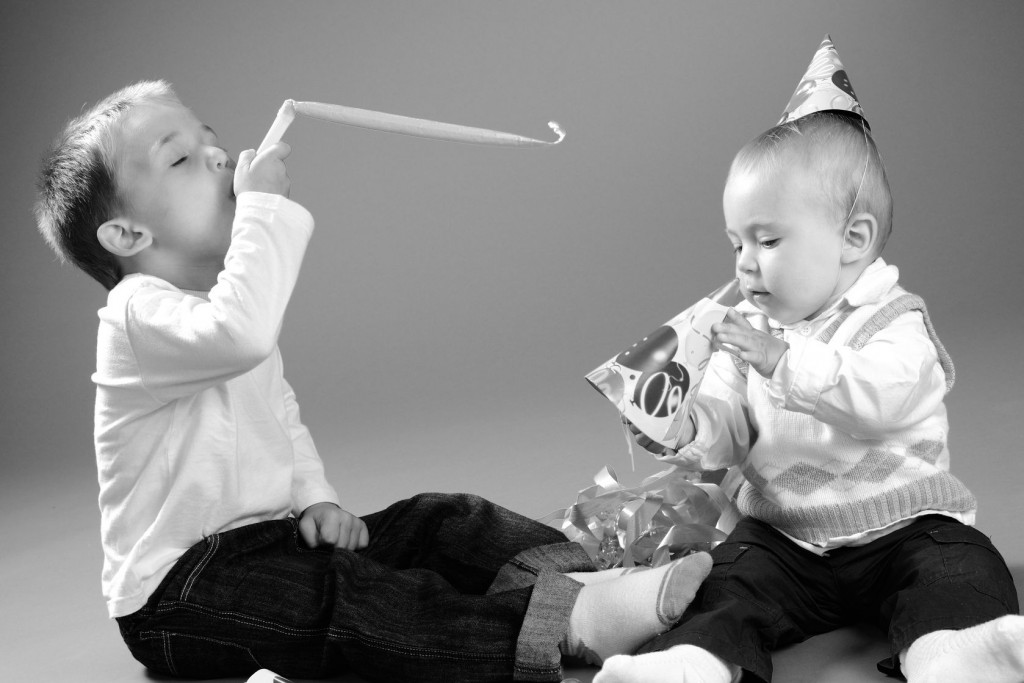 two small children playing with party favors
