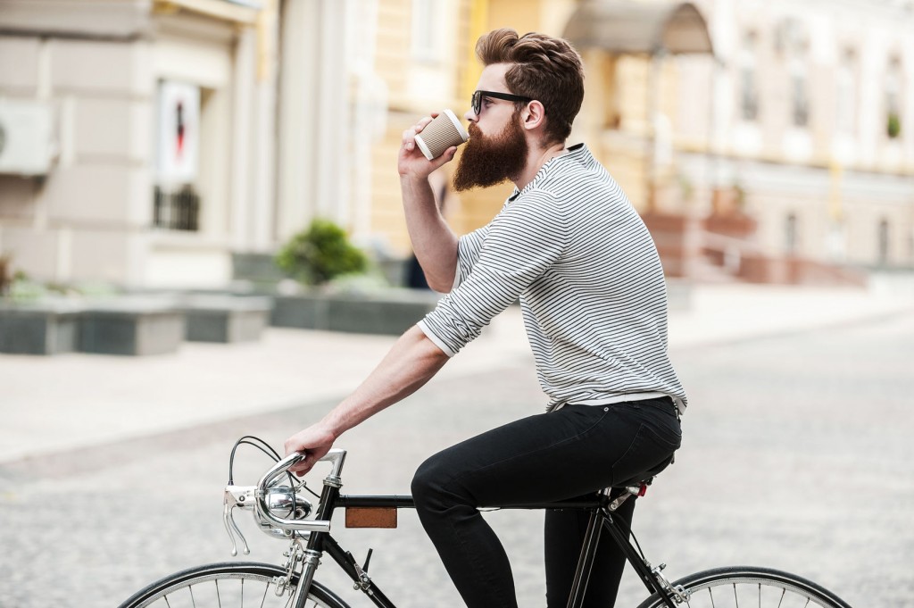 man drinking coffee on bike